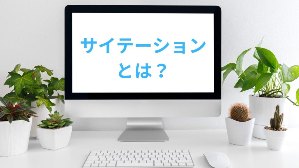 デスクトップパソコンの画面にサイテーションとは？と書いており、周りに観葉植物が置かれている画像